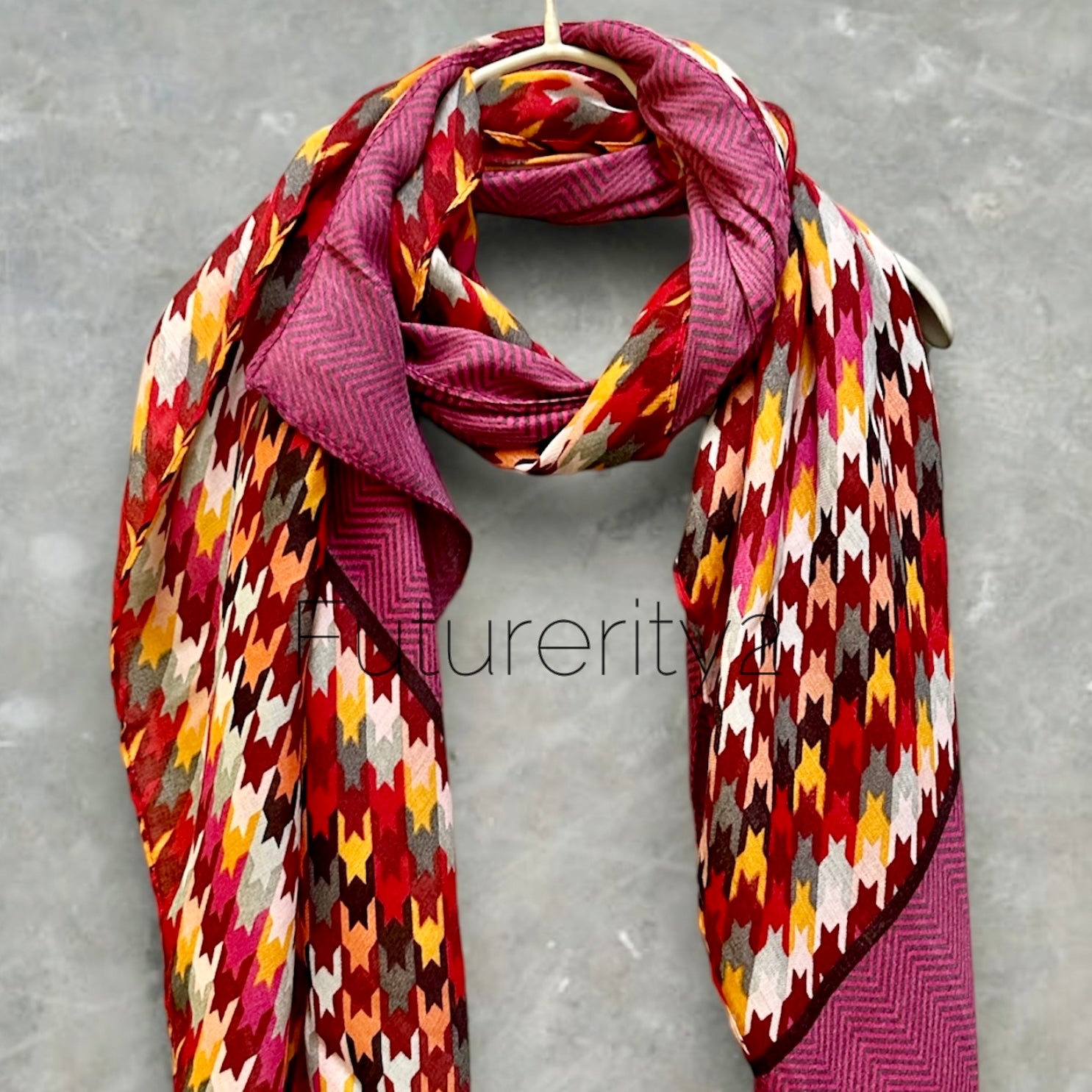 A pink, red, yellow, and gray patterned scarf with a chevron pattern on the edges.